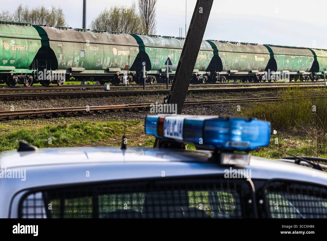 16 aprile 2023, Hrubieszow, Polonia: I carri delle tramogge di grano dell'Ucraina passano mentre la polizia sta sorvegliando la protesta degli agricoltori in corso vicino al valico di frontiera polacco-ucraino a Hrubieszow, Polonia, il 16 aprile 2023. Gli agricoltori polacchi protestano contro le importazioni di prodotti agricoli ucraini, che invece di essere trasportati attraverso la Polonia verso i paesi di destinazione, rimangono nel paese e inondano il mercato. Gli agricoltori comprendono una situazione difficile causata dall'invasione russa in Ucraina, ma sollecitano il governo polacco a regolamentare le importazioni. Il governo polacco ha annunciato il divieto Foto Stock