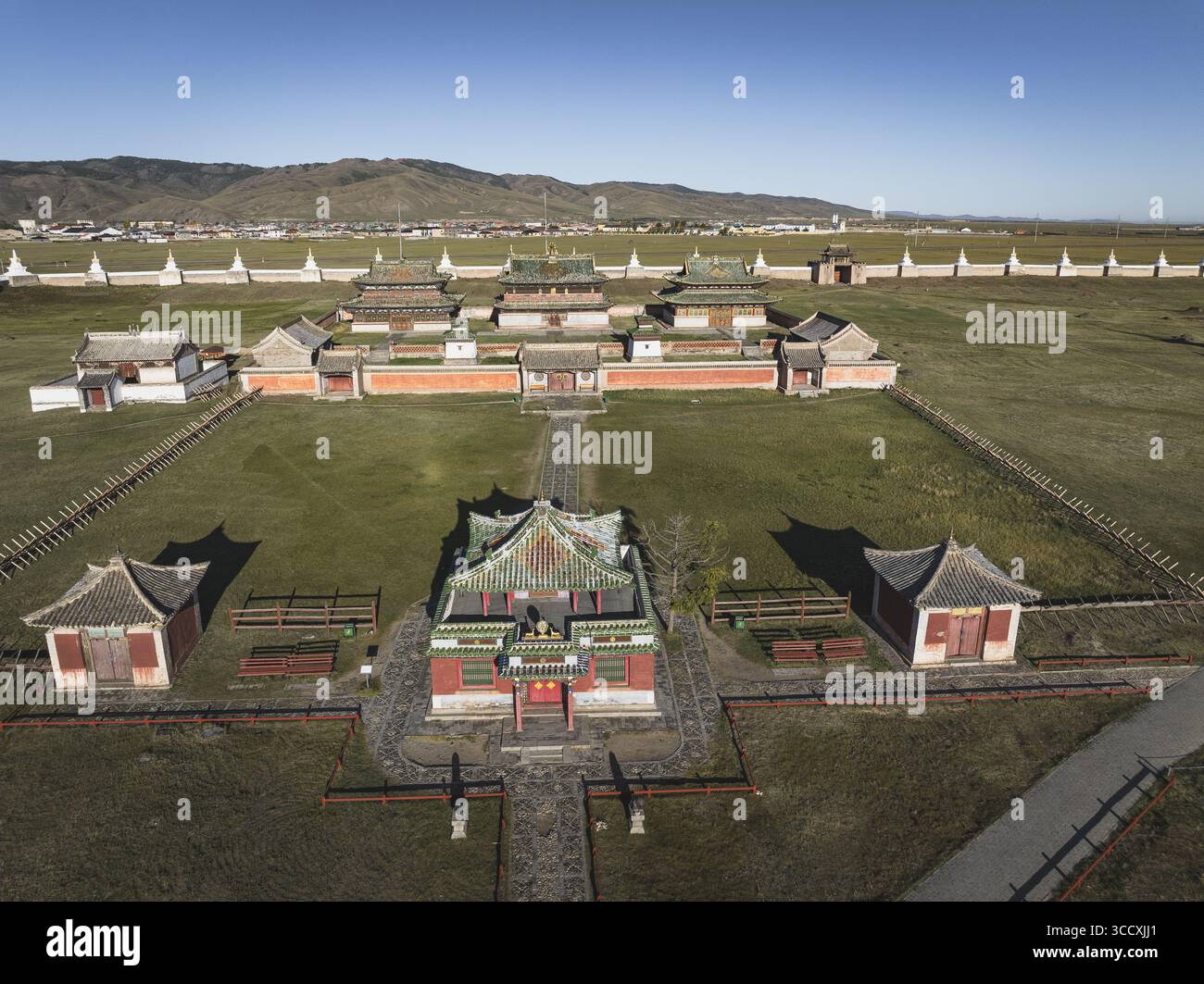 La vista aerea dei templi vivaci con tetti rossi e verdi si distingue in netto contrasto con le ampie e erbose pianure sotto un cielo limpido, Turgen, Uvs, Mongol Foto Stock