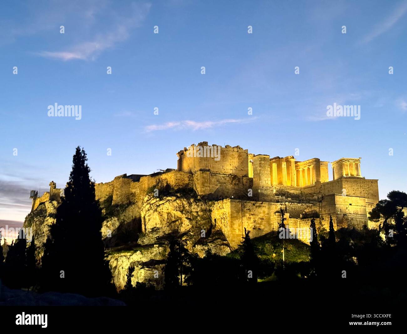 Alba all'Acropoli di Atene con una calda luce dorata che illumina le antiche rovine e una tavola informativa in primo piano. - Immagine stock catturata con smartphone
