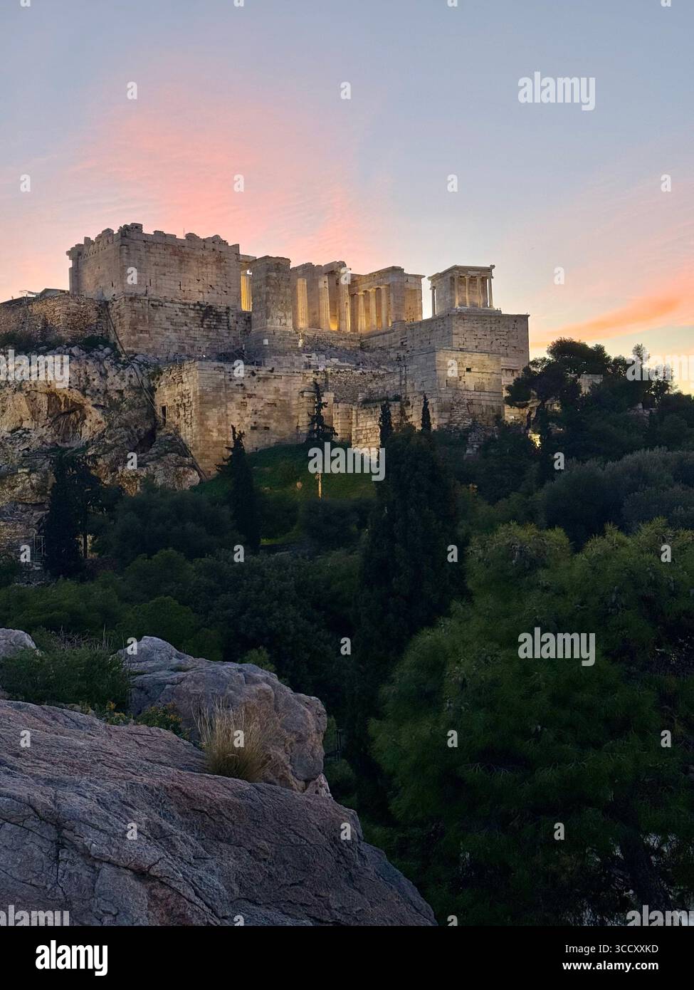 Alba sulla collina di Areopago con una calda luce mattutina che illumina l'Acropoli e il paesaggio urbano di Atene. - Immagine stock catturata con smartphone