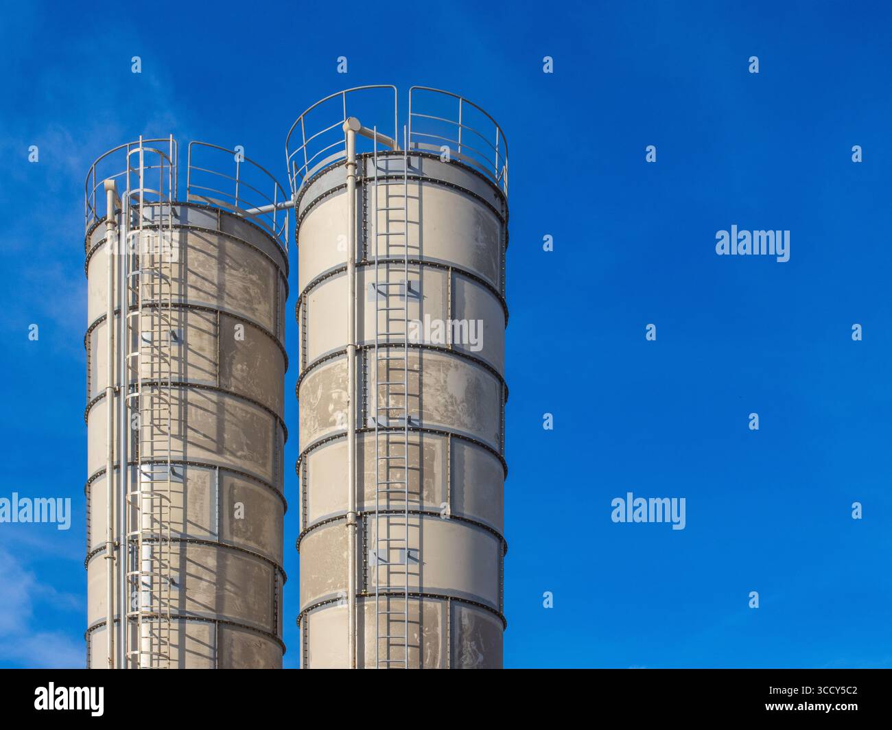 bunker industriali verticali, per lo stoccaggio di cemento, ceneri volanti o altri materiali sfusi secchi, in impianti di produzione di calcestruzzo o cantieri edili Foto Stock