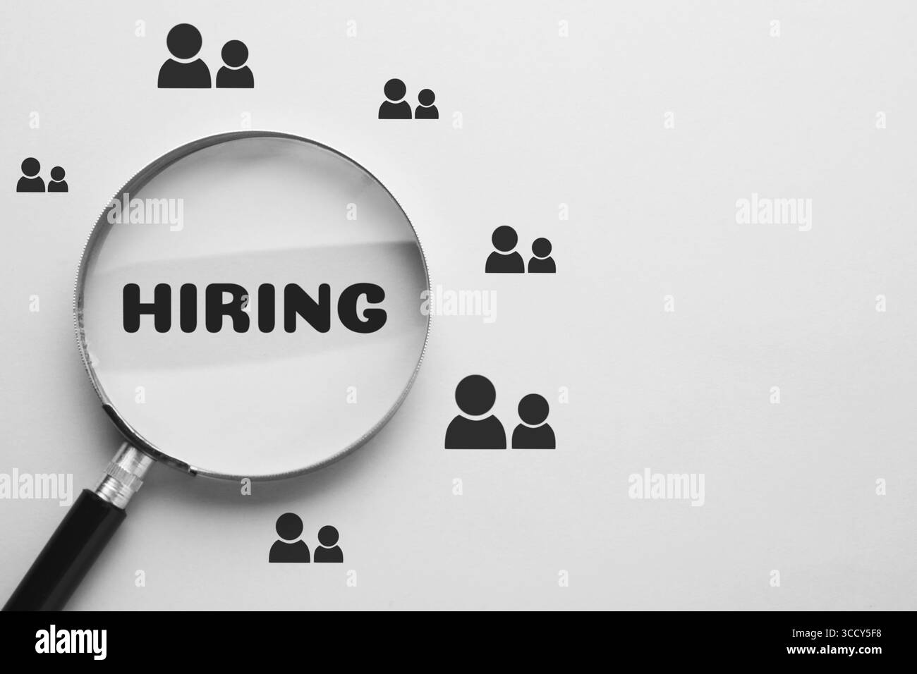 Icone di assunzione di parole e umani su sfondo bianco, visualizzate attraverso una lente di ingrandimento Foto Stock