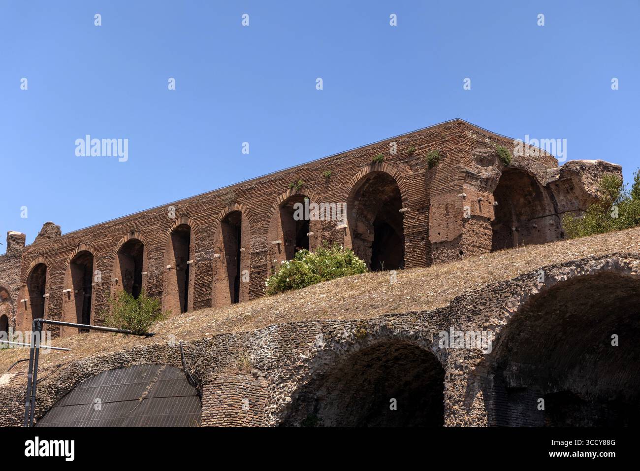 Vista sulla strada della Domus Severiana, delle antiche rovine di un palazzo romano, di Roma, Italia, che mostra l'architettura storica e il patrimonio culturale in una giornata calda Foto Stock