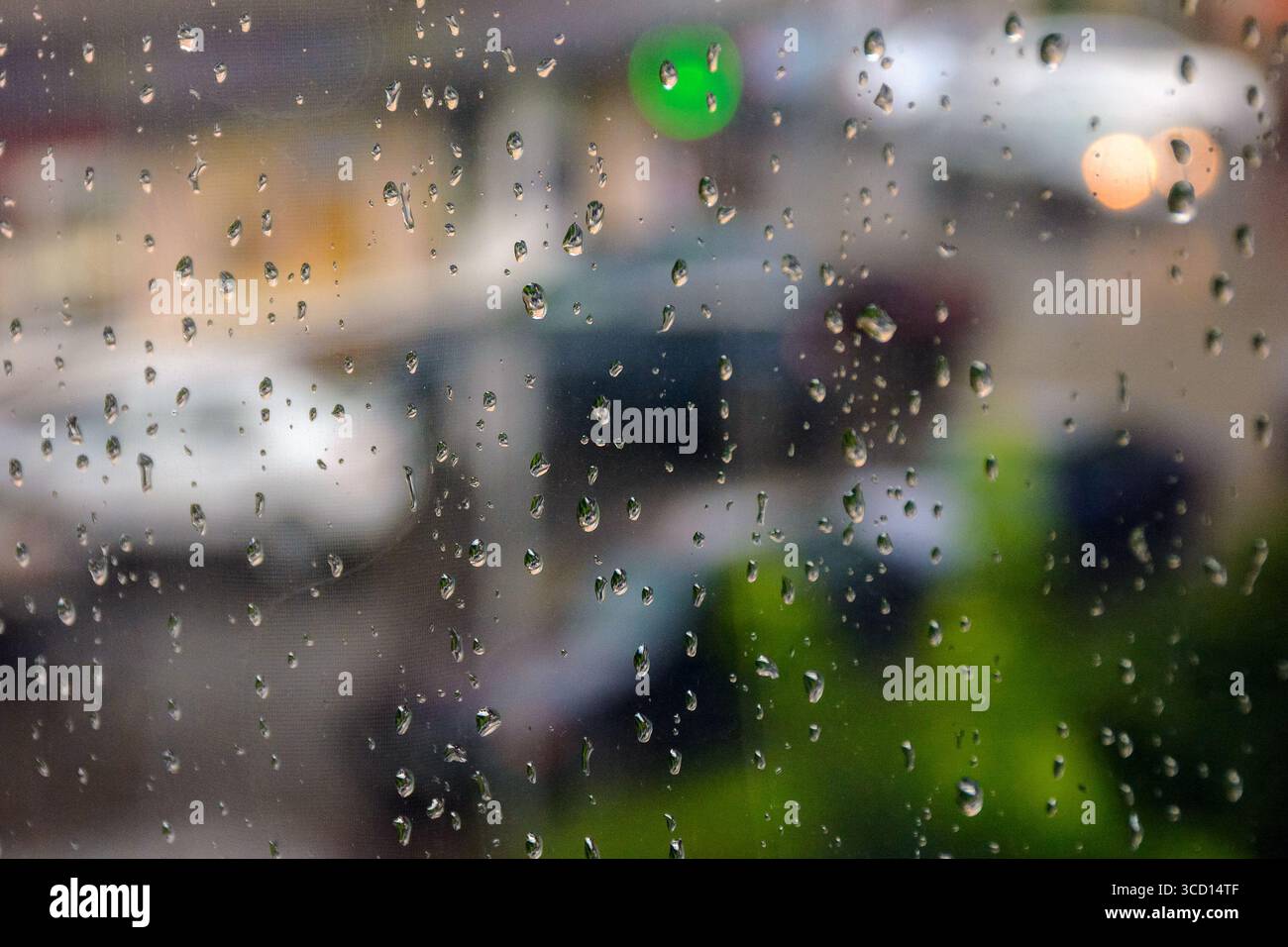 sfondo finestra bagnato. goccia di pioggia sulla superficie del vetro. concetto di maltempo. il paesaggio urbano è sfocato in lontananza Foto Stock