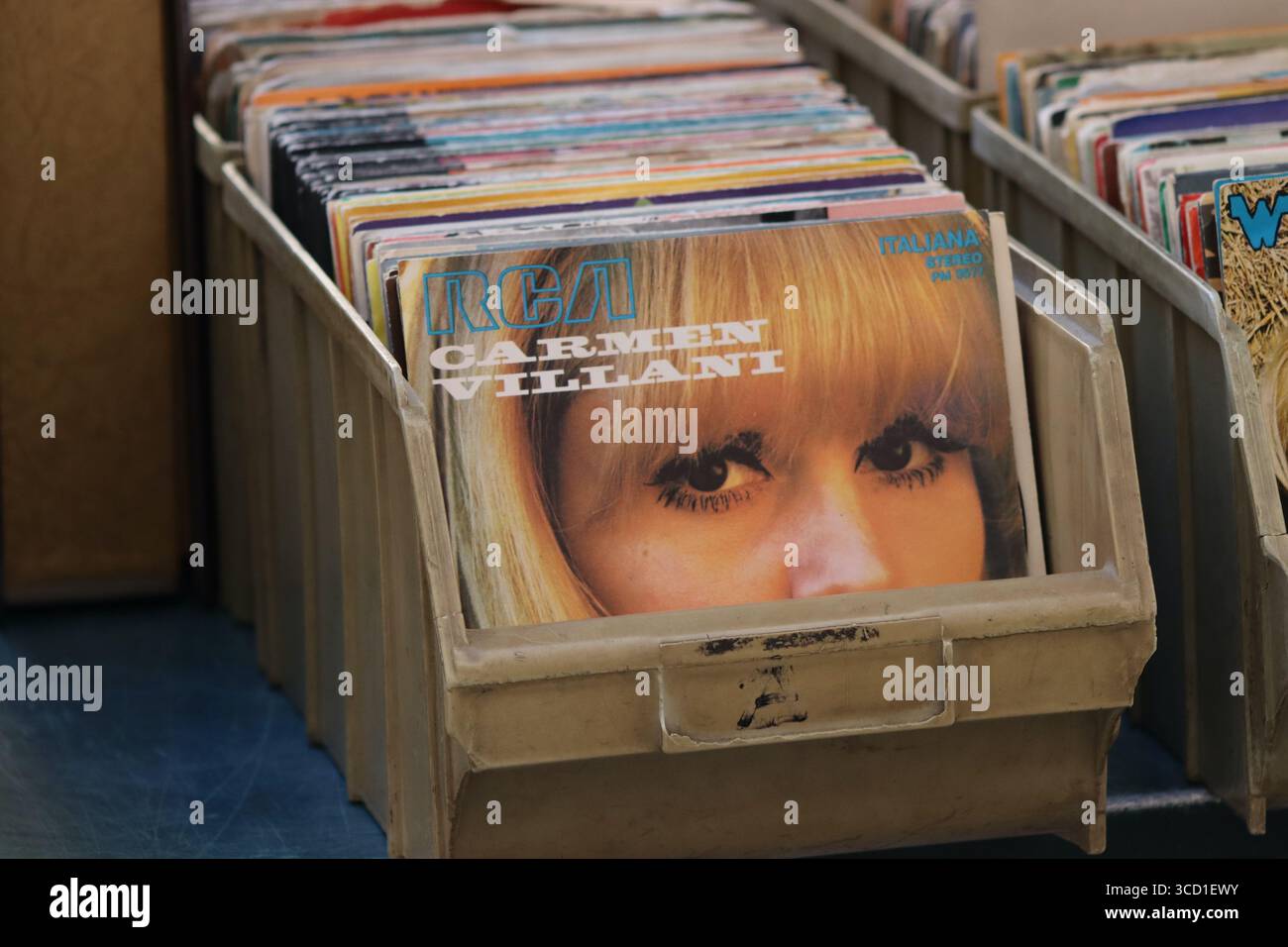 Dischi in vinile vintage da 7 pollici in vendita in una bancarella di mercato a Genova, Italia, tra cui Carmen Villani che canta "come stai" (come stai?) dal 1971. Foto Stock