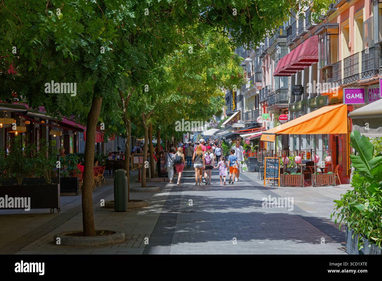 Calle de Preciados a Madrid. Atipica scena estiva di strada con ristorante al fresco e alberi ombrosi Foto Stock