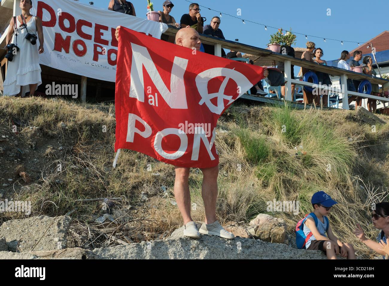 I dimostranti accolgono con favore l'arrivo delle tradizionali barche da pesca conosciute come feluche, navigando con le bandiere "No Ponte". La protesta fa parte del movimento che si oppone alla costruzione del ponte sullo stretto di Messina. Foto Stock
