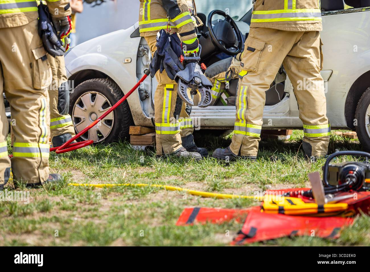 Volontari vigili del fuoco durante l'addestramento, salvataggio manichino da un'auto dopo un incidente Foto Stock