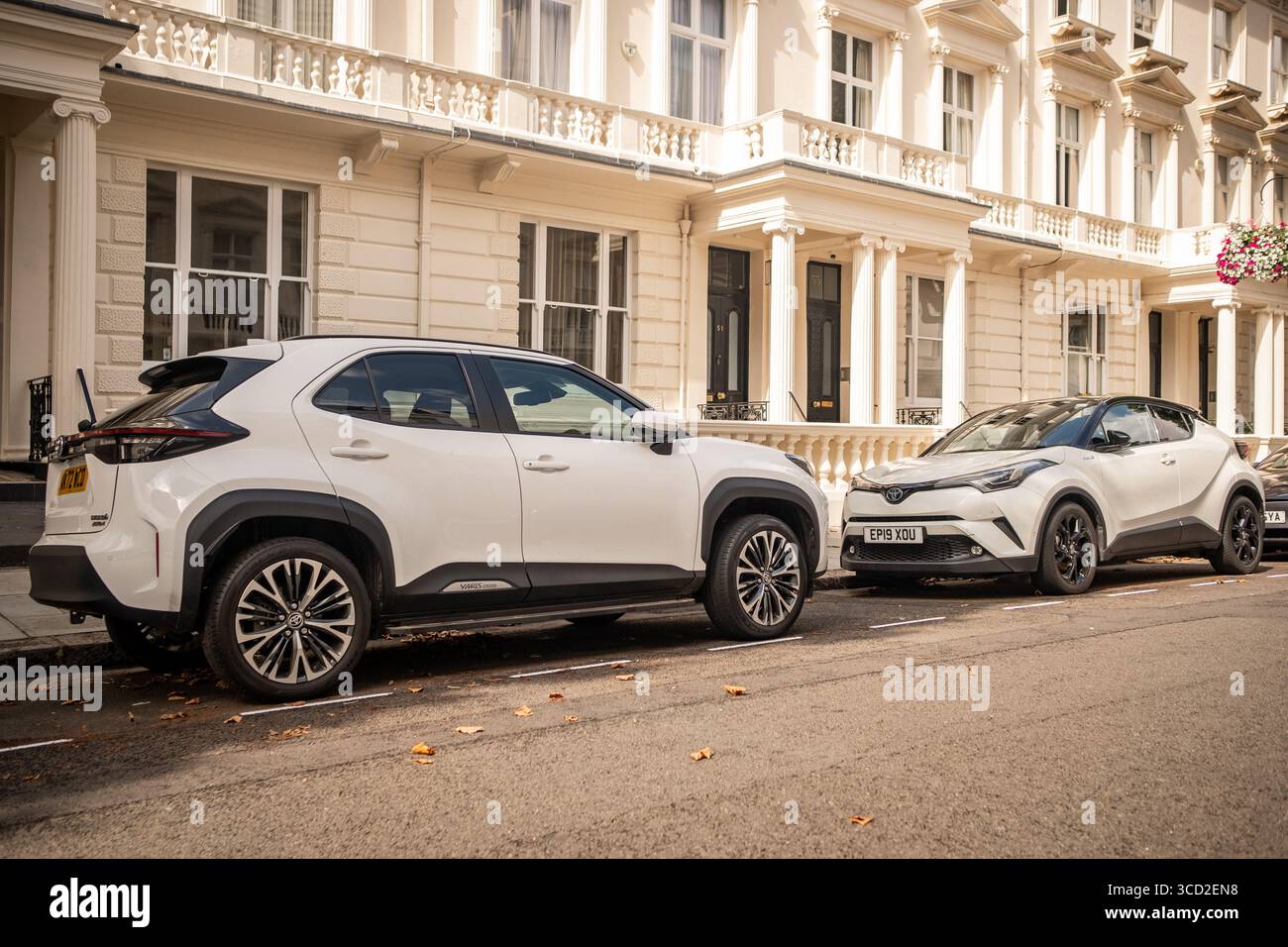 LONDRA - 23 LUGLIO 2025: Due auto Toyota bianche su strada urbana. Toyota Yaris e Toyota CHR. Casa automobilistica giapponese Foto Stock