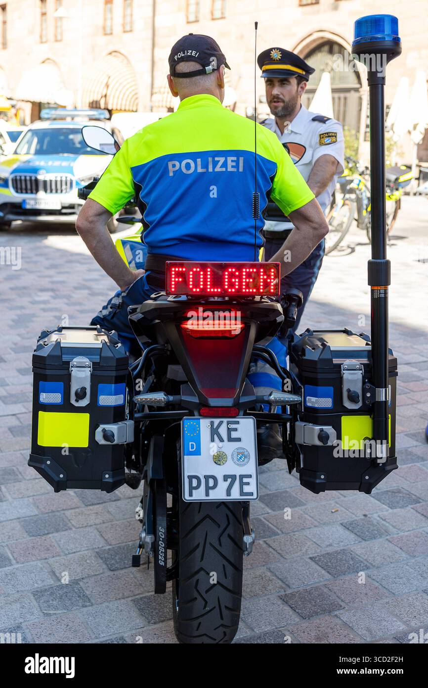 Bayerische Polizei startet Pilotprojekt mit vollelektrischen Motorrädern, Nürnberg, 12.082.2025 Ein Polizist sitzt auf einem vollelektrischen Polizeimotorrad des Herstellers Zero Motorcycles mit LED-Anzeige Folgen am Heck, präsentiert im Rahmen eines gemeinsamen Pilotprojekts der Bayerischen Polizei und der Polizei Niedersachsen. Die Motorräder werden bei der Verkehrspolizei in Nürnberg und Kelheim getestet, um Einsatzmöglichkeiten und Praxistauglichkeit zu prüfen. Im Hintergrund sind weitere Polizeikräfte und Einsatzfahrzeuge zu sehen. Nürnberg Bayern Deutschland *** la polizia bavarese lancia pi Foto Stock
