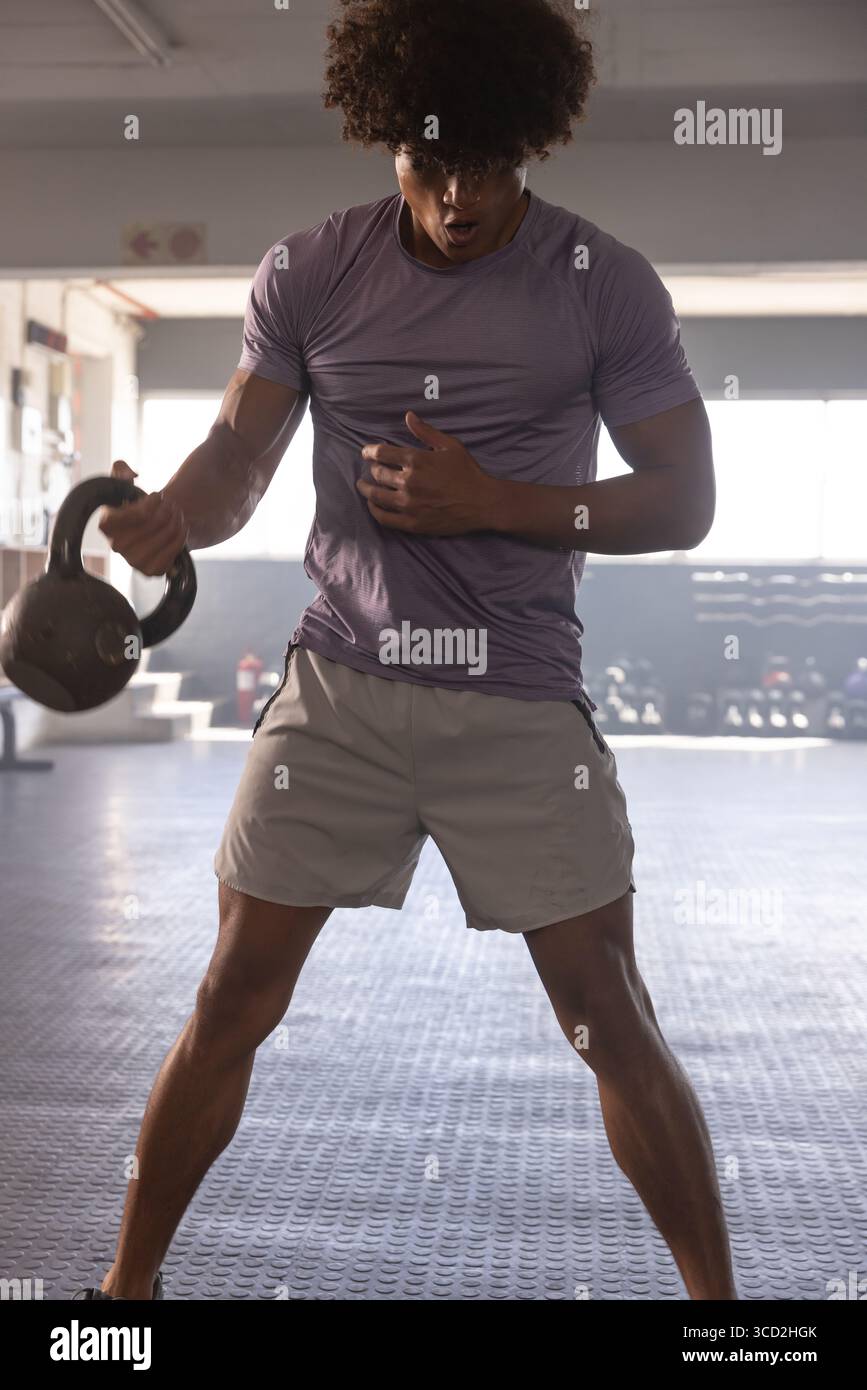 Il Kettlebell si abbassa nella zona della palestra per allenamento funzionale, con portapacchi e luce naturale Foto Stock