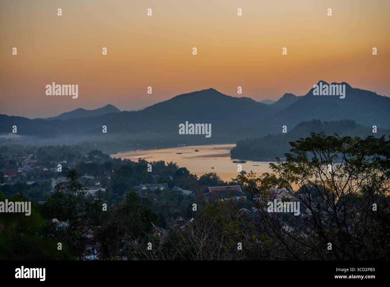 Vista al crepuscolo sul fiume Mekong e sulle montagne a Luang Prabang, Laos al tramonto con nebbia e luce soffusa serale Foto Stock