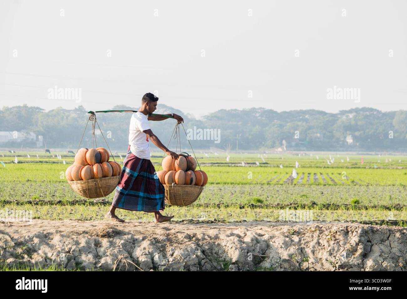 18 dicembre 2022 - il vasaio del popolo del Bangladesh porta i suoi vasi di ceramica di terra per la vendita nel mercato locale attraverso una strada del villaggio oggi. Foto Stock