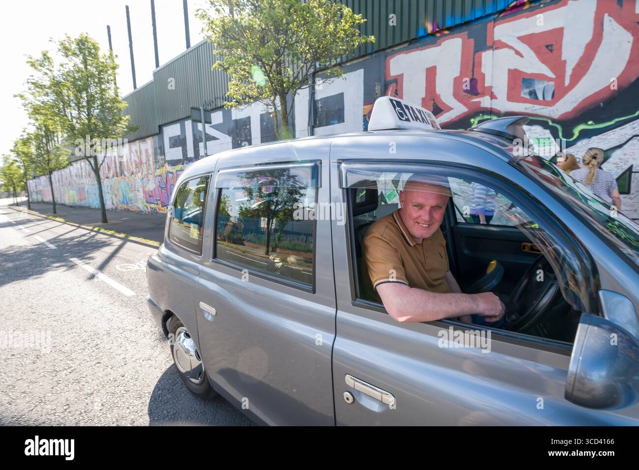 Guida maschile seduta in taxi durante un tour in taxi nero di Belfast, Contea di Antrim, Irlanda del Nord, Regno Unito Foto Stock