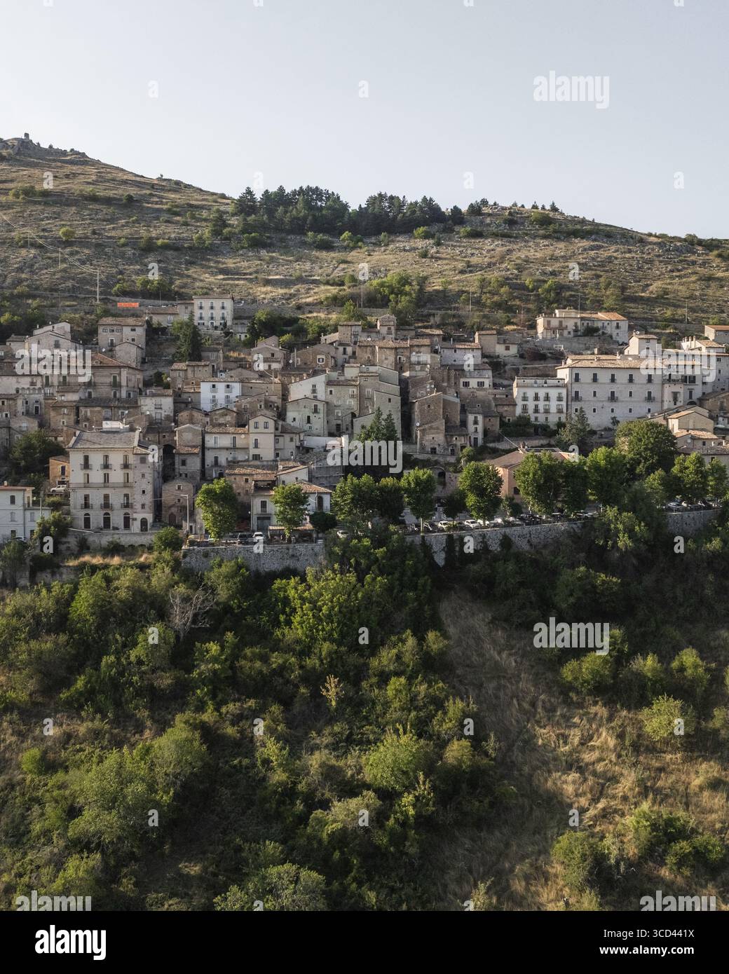 Vista aerea di antichi edifici in pietra aggrappati alla collina, una città fortezza immersa nella storia, immersa nel caldo bagliore del sole italiano, Rocca Calascio, Abruzzo, Italia. Foto Stock