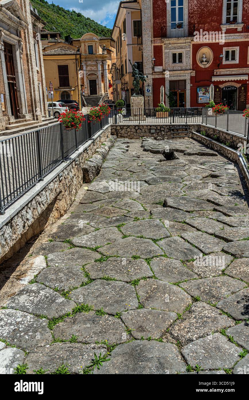 Un frammento di pavimentazione storica romana situato nella piazza della città, che rivela intricati lavori in pietra e l'eredità architettonica dell'antica pianificazione urbana. Foto Stock