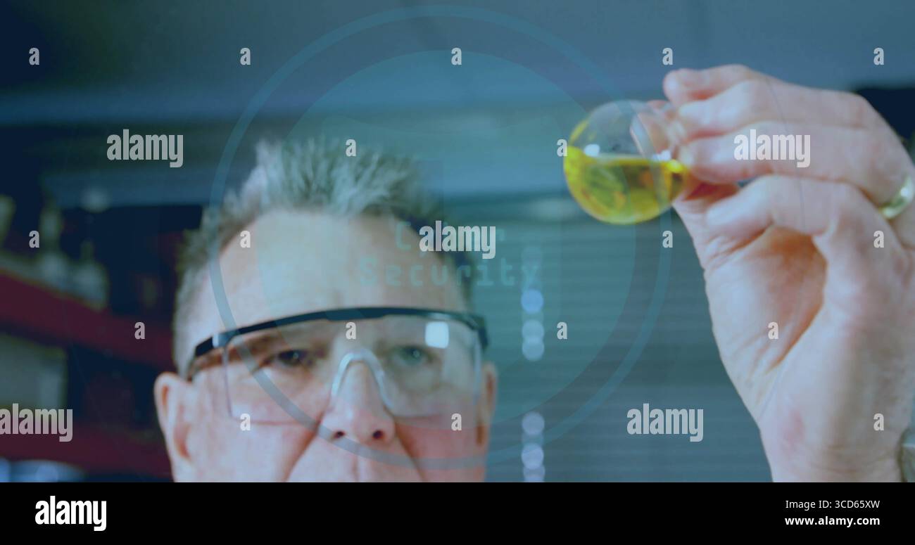 Scienziato senior che indossa un camice da laboratorio e occhiali di sicurezza, che esamina il matraccio rotondo di liquido giallo in laboratorio Foto Stock