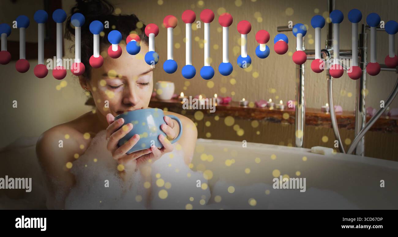 Donna ammollo che tiene in mano la tazza blu nella vasca da bagno riempita di schiuma, con una grafica a elica di candele e luci accese Foto Stock