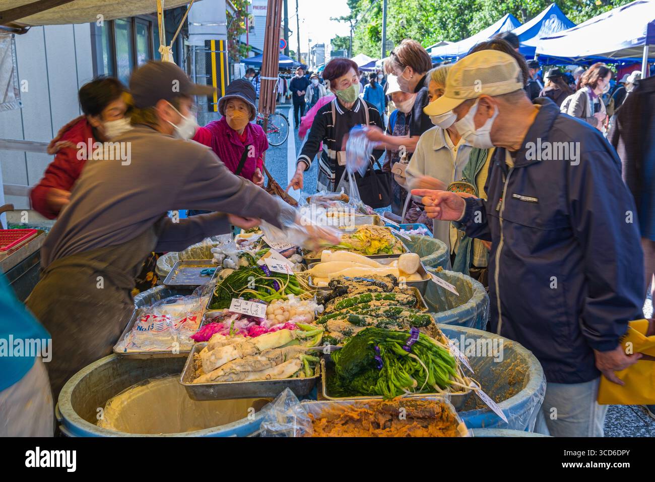 Persone che acquistano prodotti freschi per la vendita durante il mercato mensile delle pulci al santuario Tenmangu, Bakurocho, Kamigyo Ward, Kyoto, Kansai, Honshu, Giappone Foto Stock
