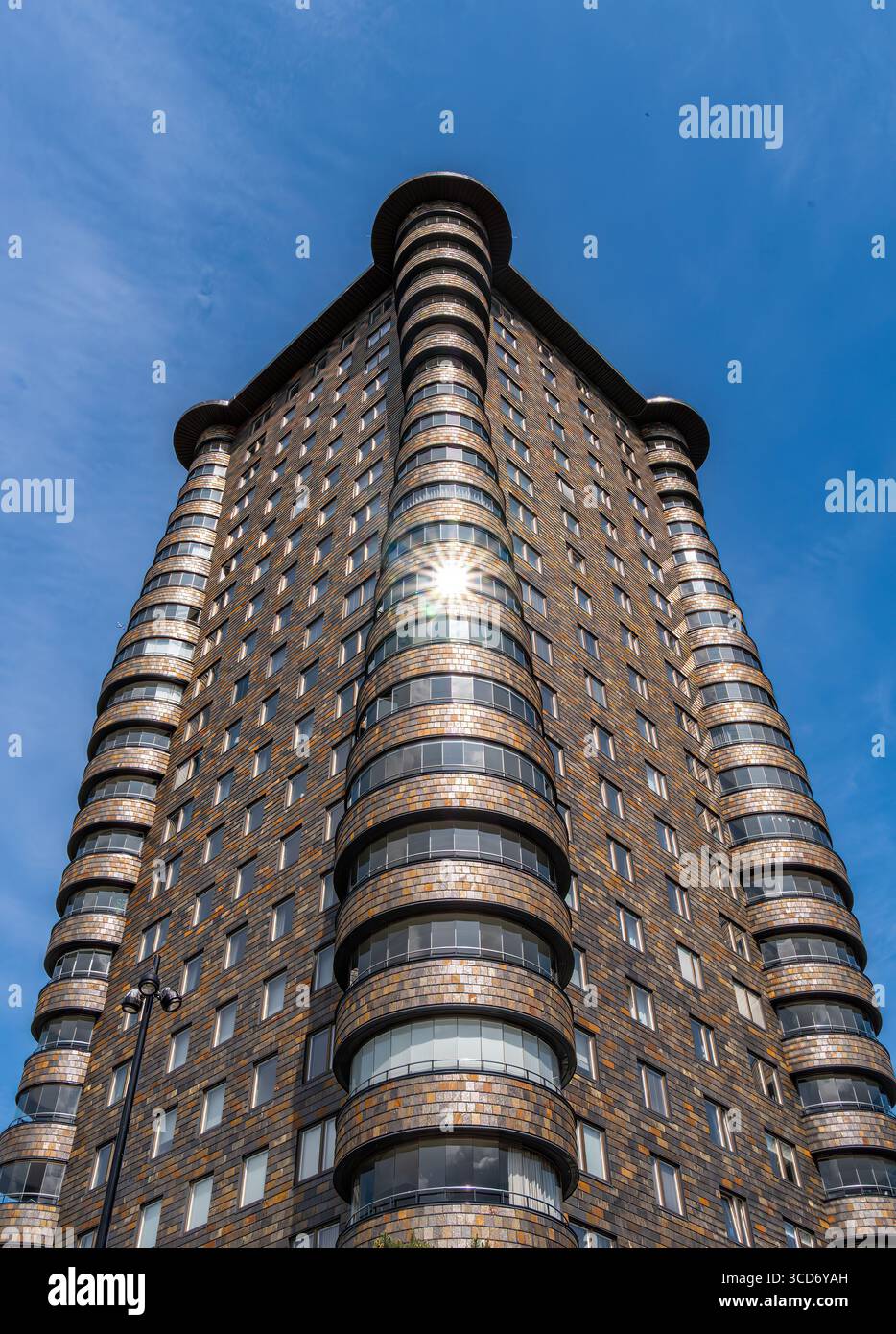 Stoccolma, Svezia - 10 giugno 2025: Un alto e moderno edificio con un design cilindrico unico e finestre riflettenti, adagiato su di un cielo azzurro. Foto Stock Stoccolma, Svezia - 10 giugno 2025: Un alto e moderno edificio con un design cilindrico unico e finestre riflettenti, adagiato su di un cielo azzurro. Foto Stock