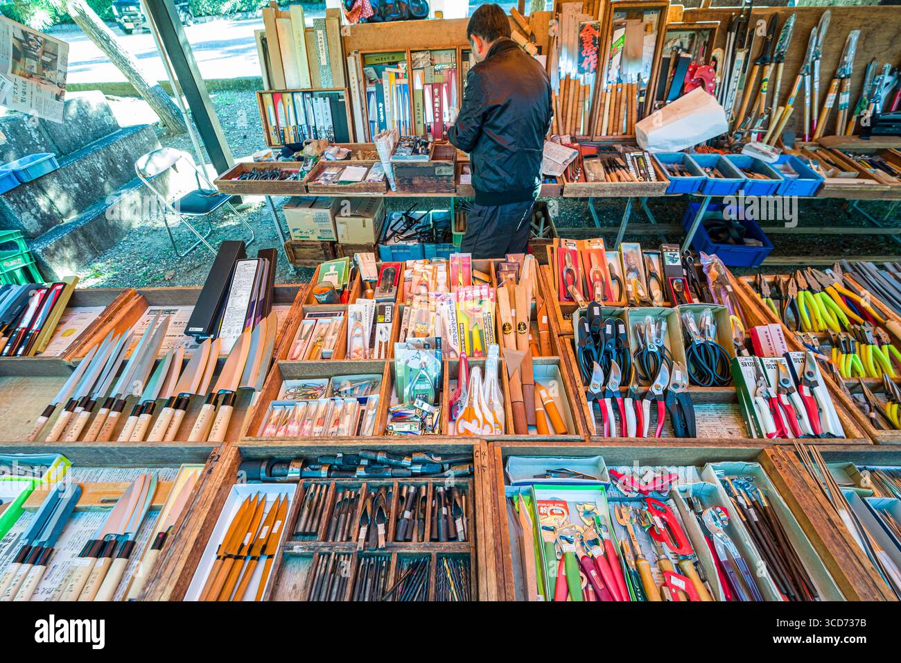 Tavolo ricoperto di vassoi di legno che contengono vari utensili manuali in vendita durante il mercato mensile delle pulci al santuario Tenmangu, Bakurocho, Kamigyo Ward, Kyoto, Foto Stock
