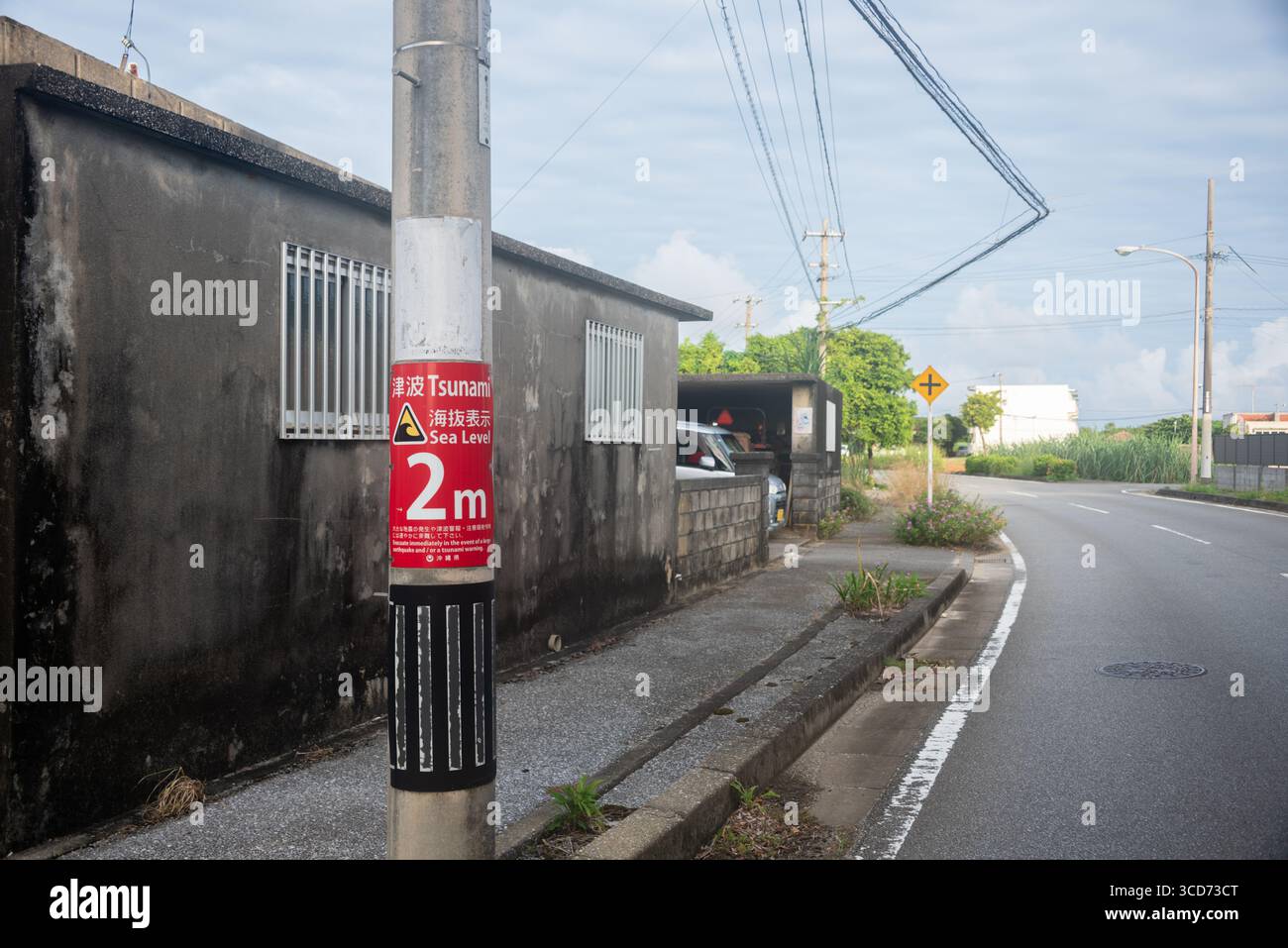 Cartello di avvertimento Tsunami a 2 metri sulla strada dell'isola di Miyakojima nella prefettura di Okinawa, Giappone Foto Stock