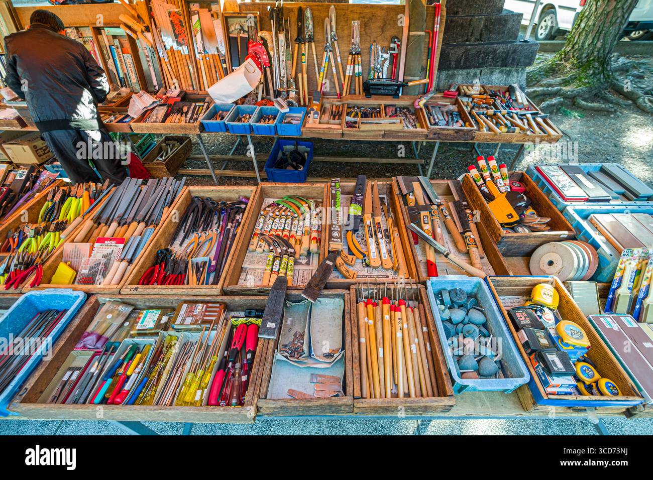 Tavolo ricoperto di vassoi di legno che contengono vari utensili manuali in vendita durante il mercato mensile delle pulci al santuario Tenmangu, Bakurocho, Kamigyo Ward, Kyoto, Foto Stock