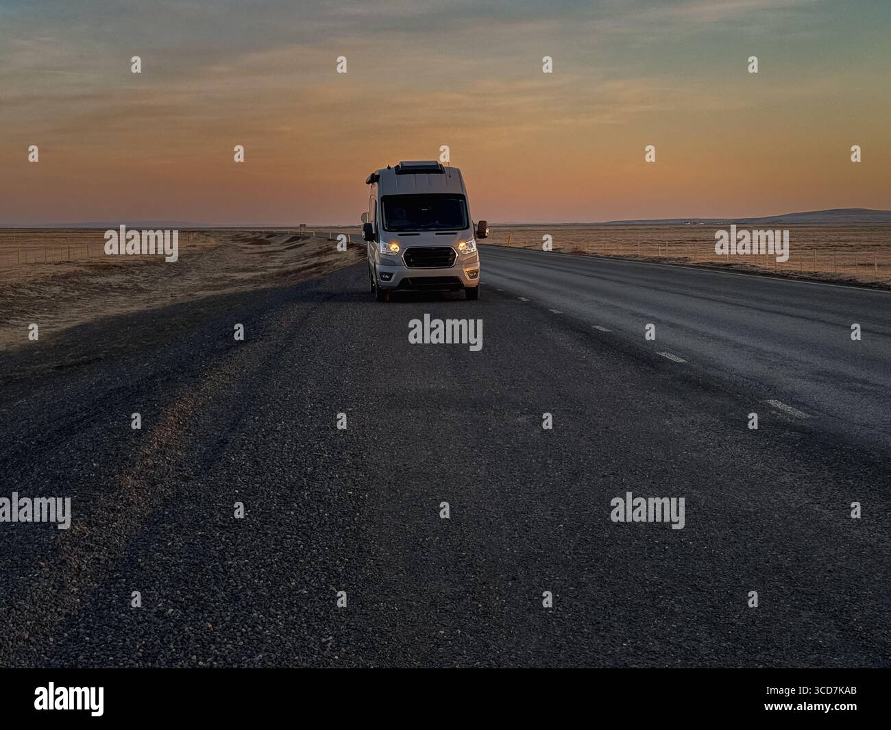 Camper sulla strada islandese all'alba Foto Stock