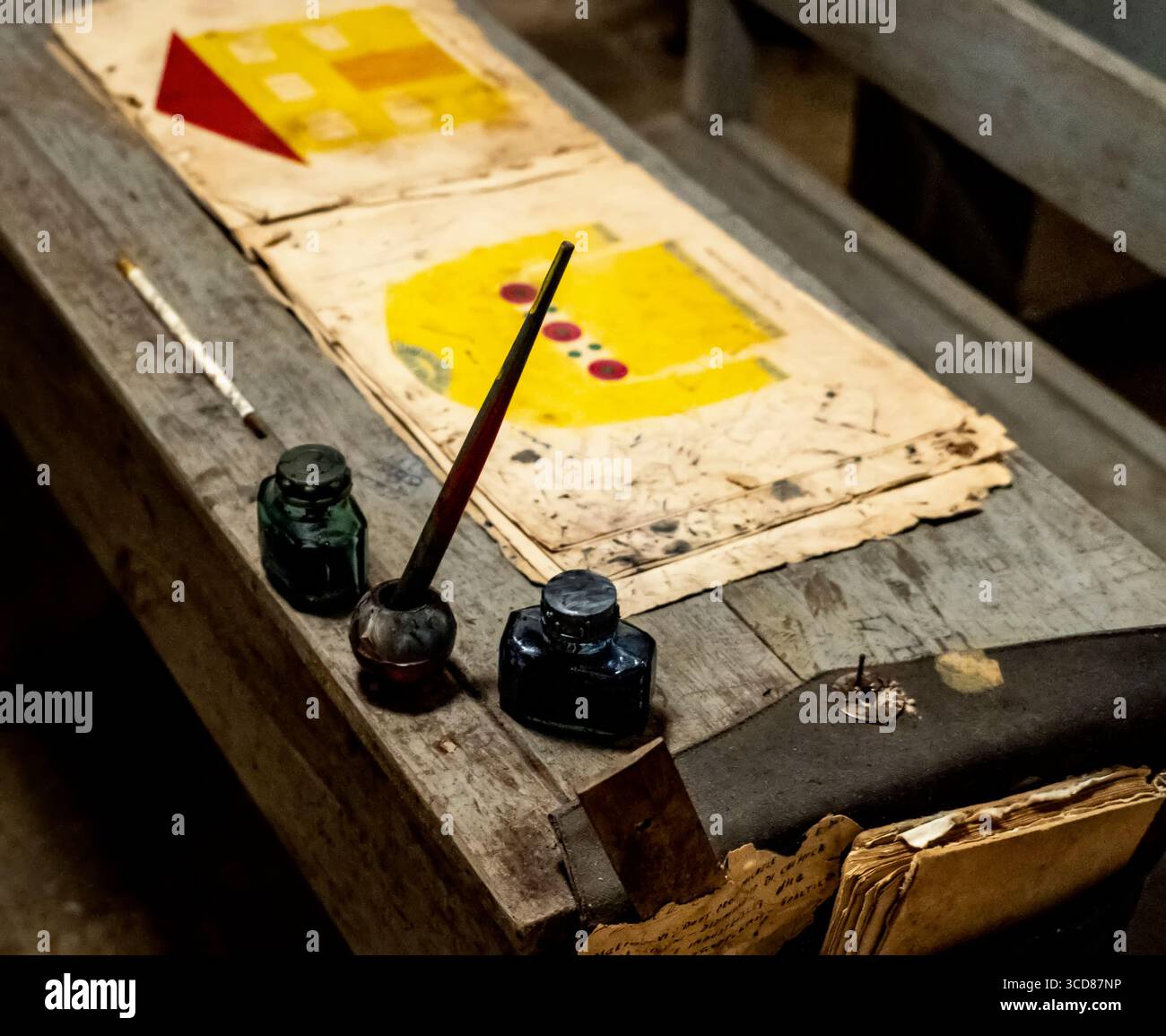 Scrivania scolastica d'epoca con bottiglie d'inchiostro, trapunta e vecchi disegni. Foto Stock