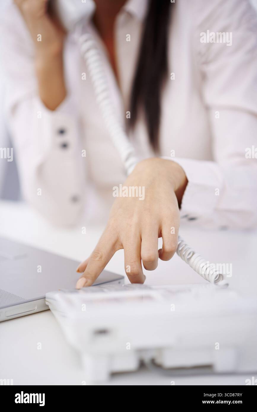 Primo piano di una donna che compone il numero sulla tastiera del telefono Foto Stock