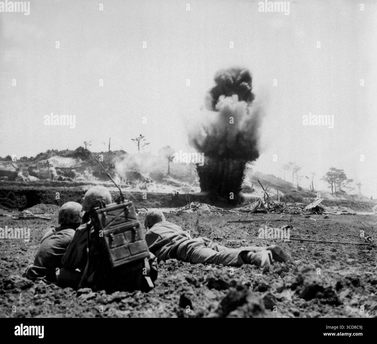 OKINAWA, GIAPPONE - maggio 1945 - Un equipaggio di demolizione della 6a Divisione Marines del corpo dei Marines degli Stati Uniti guarda le cariche di dinamite esplodere e distruggere un Giappone Foto Stock
