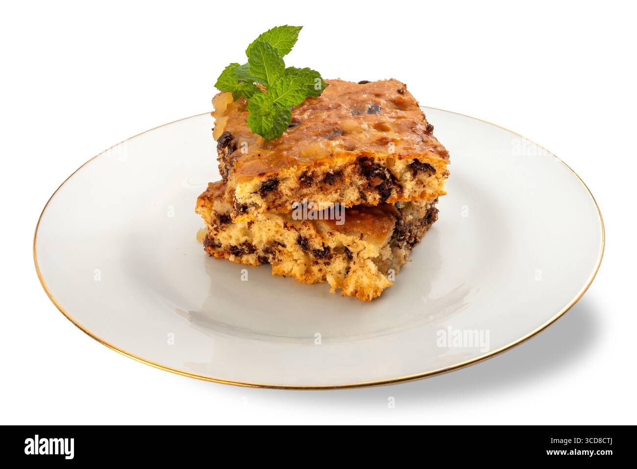 Fette di torta alla frutta con marmellata di cioccolato e arancia con foglie di menta fresca su un piatto bianco con bordo dorato isolato su bianco con pa ritagliato Foto Stock