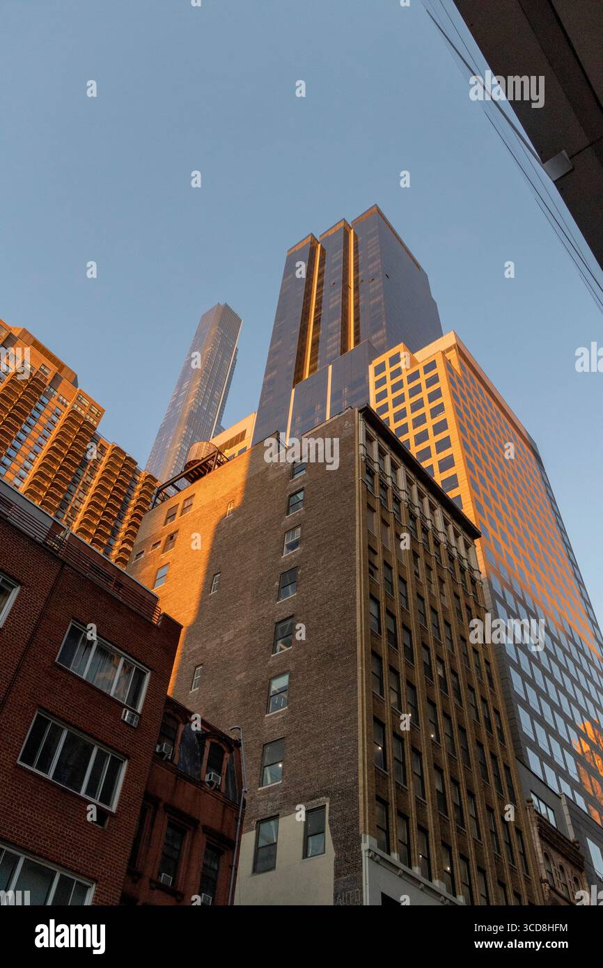 Guardando in alto al Park Imperial, West 55th Street a Manhattan, New York City, USA, con edifici urbani e skyline che torreggiano sopra Foto Stock