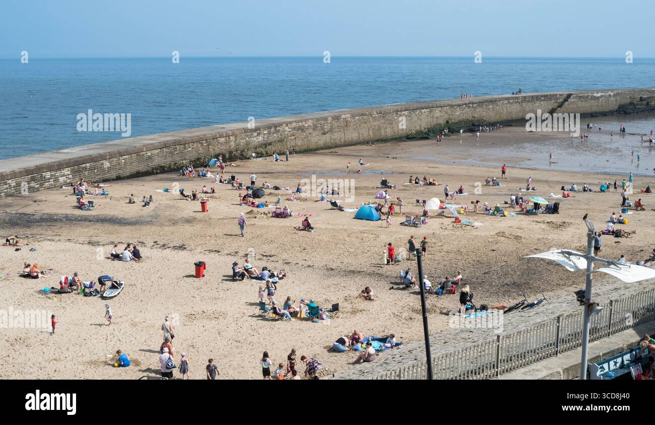 Famiglie che amano il sole estivo sulla spiaggia di Seaham Slope, Seaham Harbour, Co Durham Foto Stock