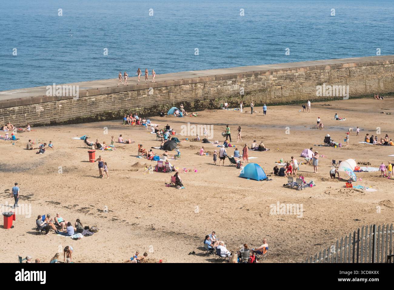 Famiglie che amano il sole estivo sulla spiaggia di Seaham Slope, Seaham Harbour, Co Durham Foto Stock