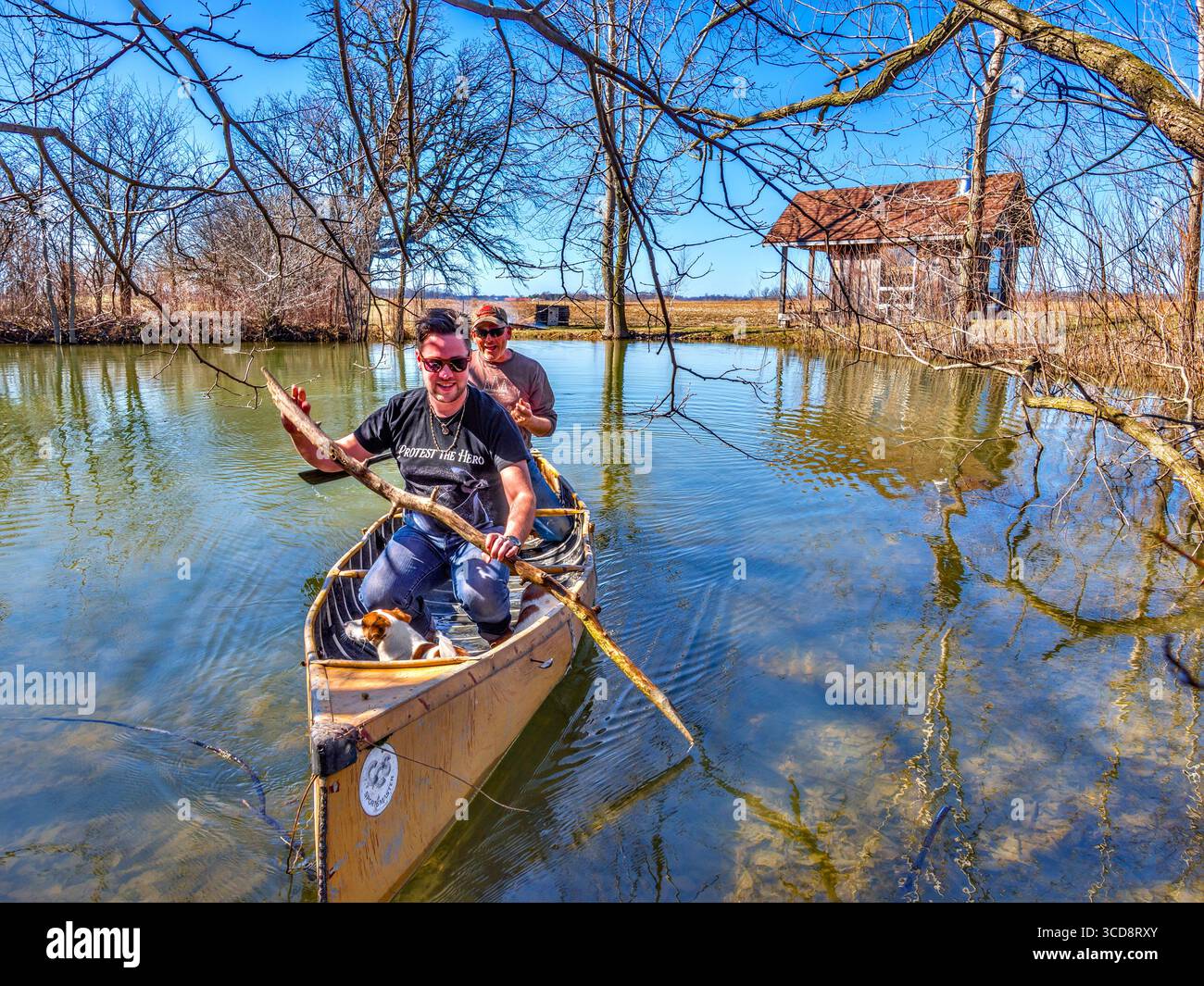 Padre e figlio vanno in canoa sul piccolo laghetto in una capanna per il fine settimana in famiglia - Glencoe, Ontario, Canada. Foto Stock