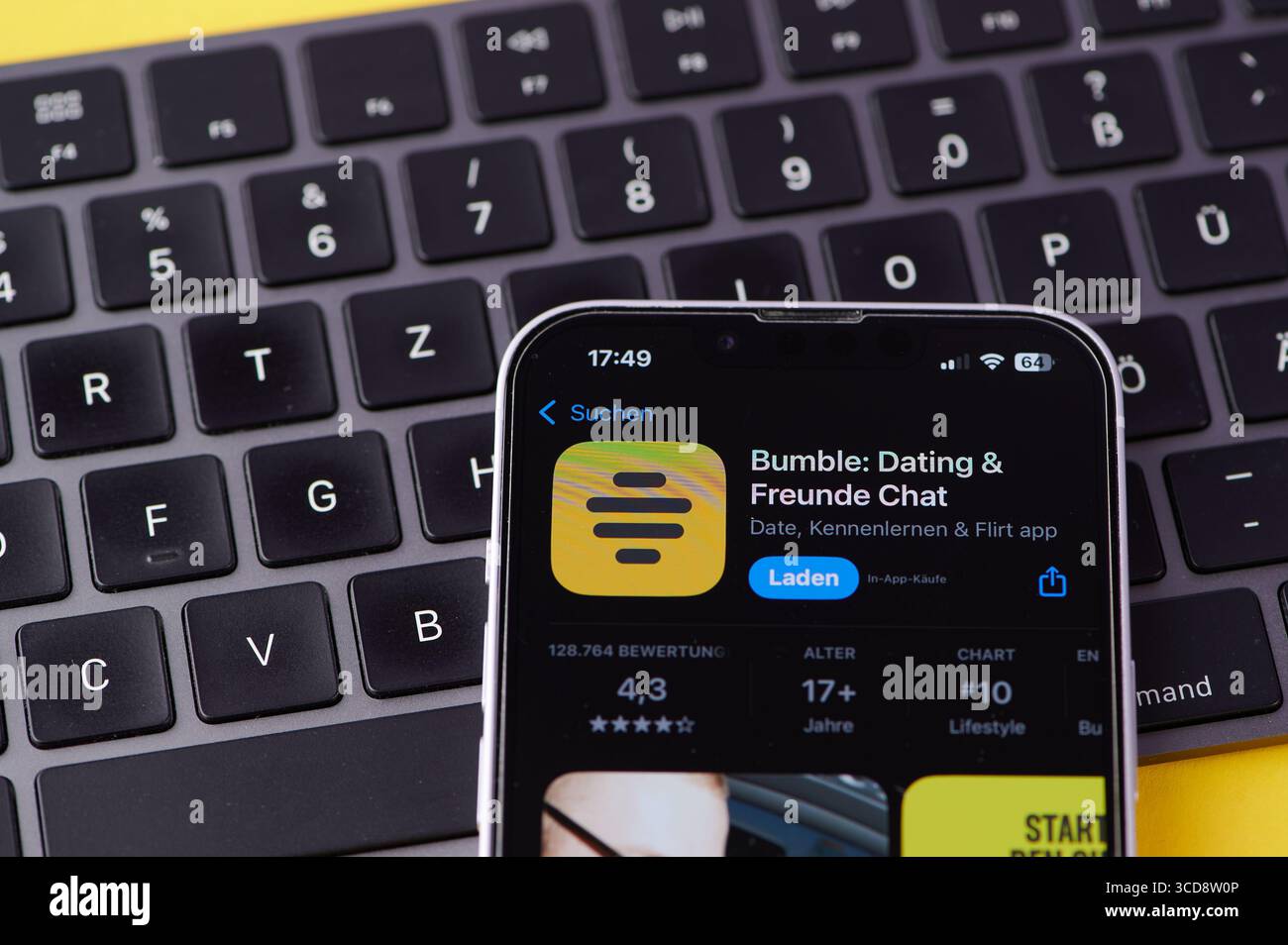 Magonza, Germania - 10 agosto 2025: Uno smartphone presenta il logo del bumble dell'app di incontri mentre si trova accanto alla tastiera di un computer. Foto Stock