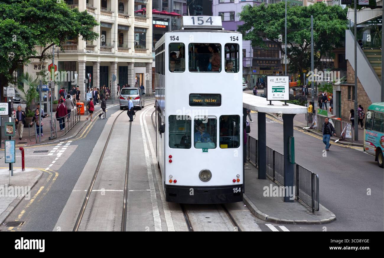Una vista frontale di un tradizionale tram bianco di Hong Kong senza loghi ad una fermata del tram in Johnstone Road Foto Stock