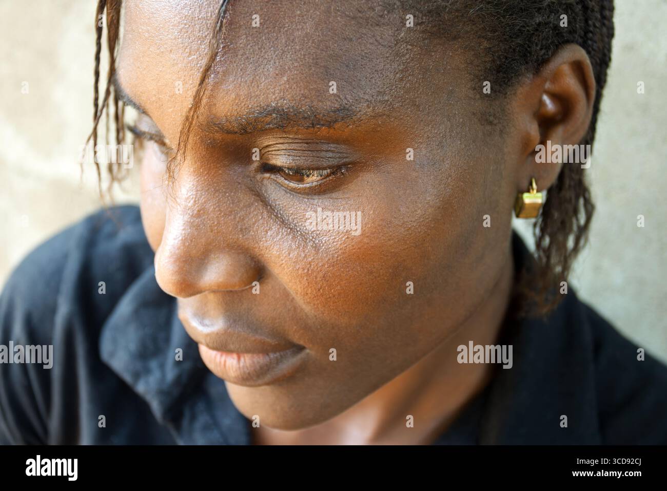 ritratto alla testa di una donna africana con trecce, affaticata e stanca, emozione preoccupata, all'aperto, sfondo neutro Foto Stock