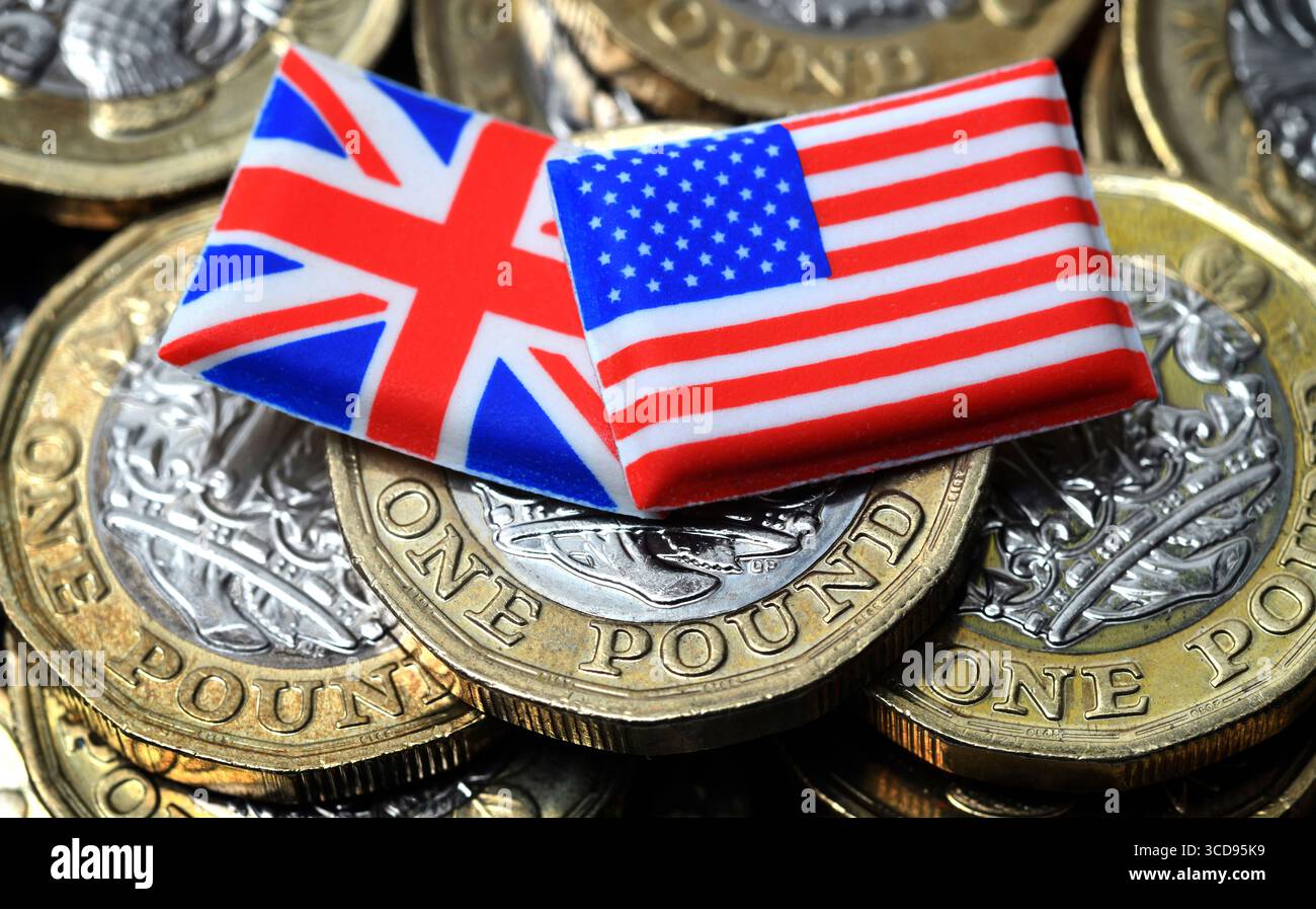 LE BANDIERE BRITANNICHE E AMERICANE CON MONETE DA UNA STERLINA RIPAGANO I TASSI DI CAMBIO DELLA STERLINA DEL DOLLARO DELL'ECONOMIA ETC UK Foto Stock