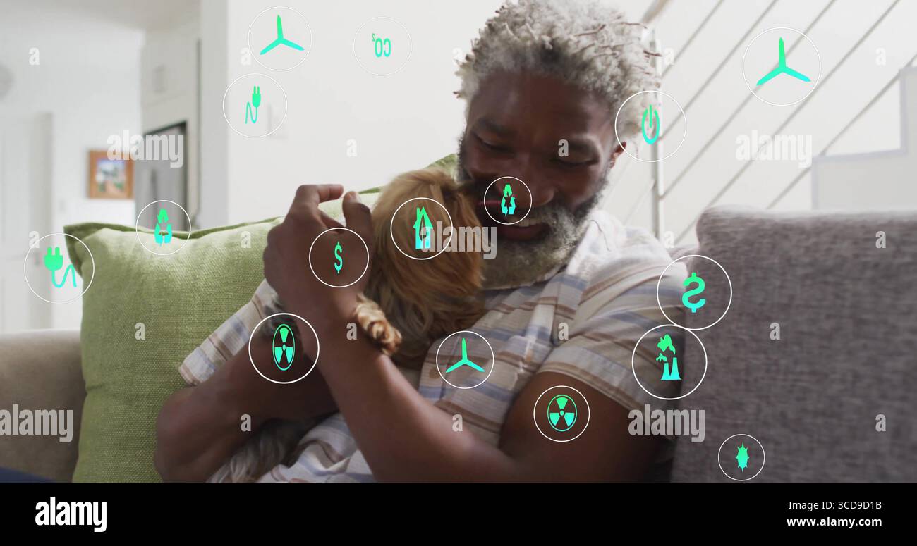 Uomo che indossa una camicia a righe che abbraccia un cane marrone sul divano in salotto, con icone digitali dell'energia Foto Stock
