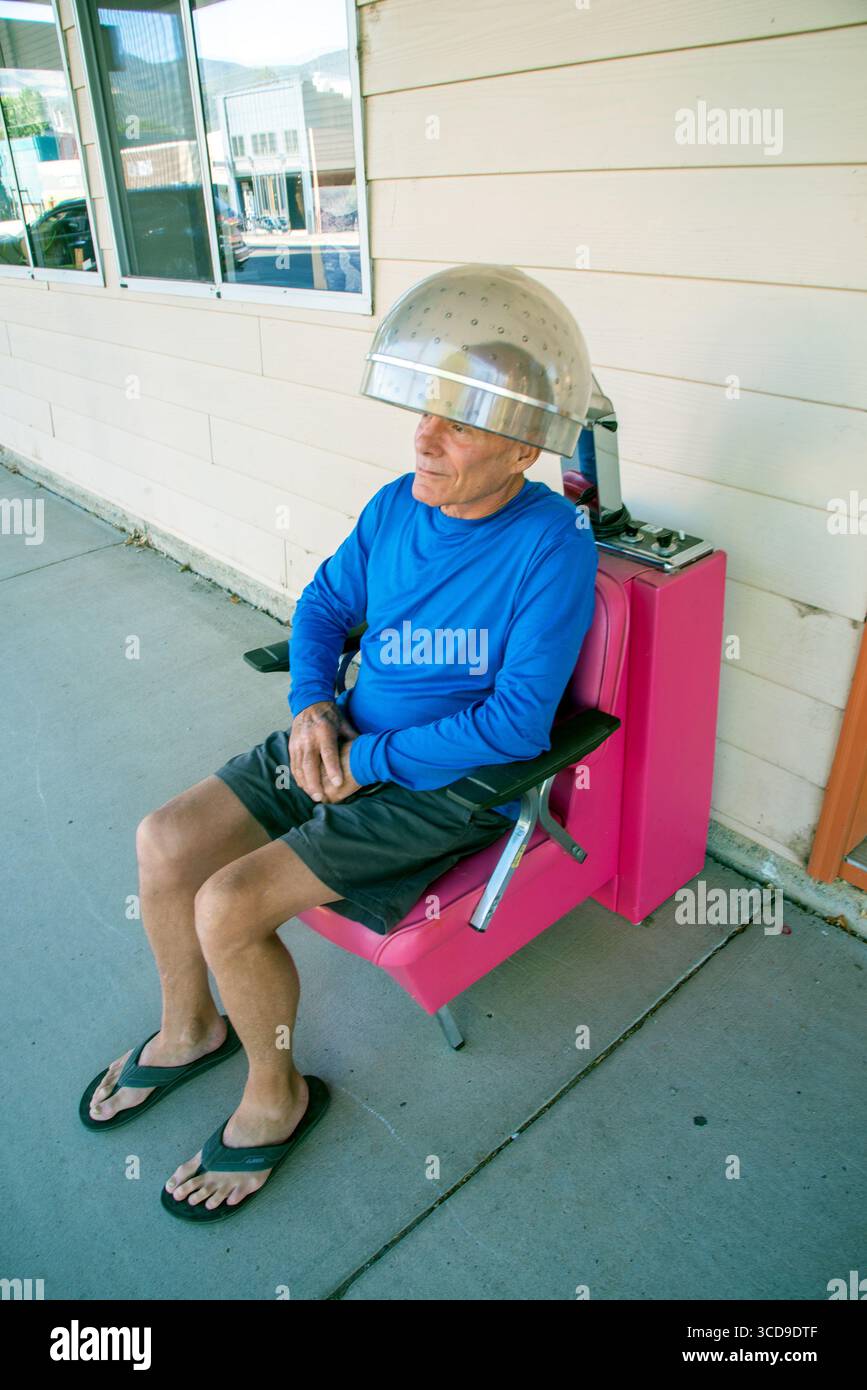 Un maschio calvo adulto ha i suoi capelli sottili curati professionalmente in un salone all'aperto di Paonia, Colorado Foto Stock