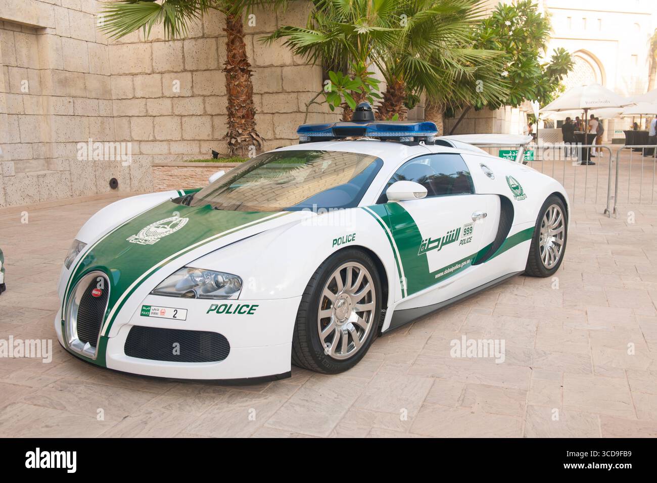 Supercar di lusso Bugatti Veyron della polizia di Dubai parcheggiata all'aperto vicino a palme e architettura in pietra a Dubai, UAE. Foto Stock