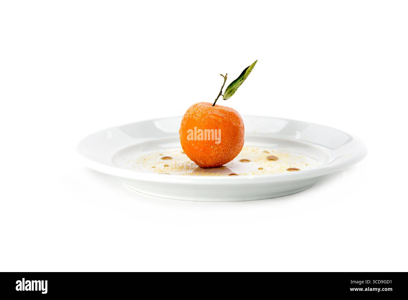 Un dessert di frutta alle mandarine fresco con una foglia verde servito su un piatto di ceramica bianca con sciroppo di salsa gourmet. Foto Stock