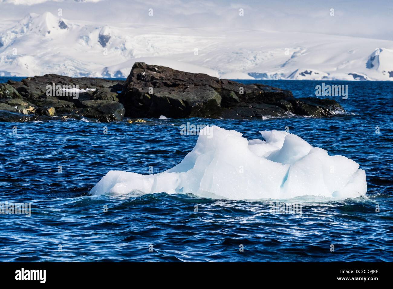 Un tranquillo paesaggio antartico, vicino al porto di Mikkelsen sull'Isola Trinity, che mette in evidenza forti riflessi, aspre montagne e suggestivi iceberg Foto Stock
