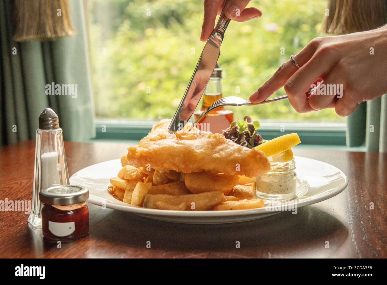 Fish and chips con piselli e salsa di tartaro. Cucina tradizionale inglese. Foto Stock