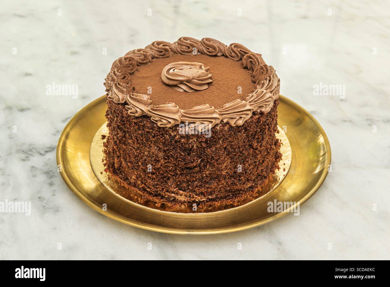Tradizionale ricetta per torta al cioccolato tres leches, ricoperta da un composto cremoso e condita con crema Chantilly Foto Stock