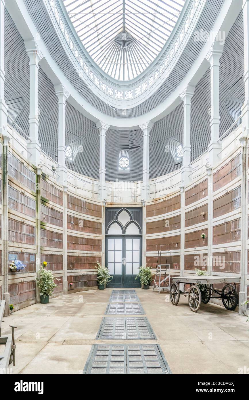 Interno illuminato dal sole del Monumento funerario municipale di Porto. Storiche mura in pietra, design ad arco, tranquilla atmosfera da cimitero europeo Foto Stock