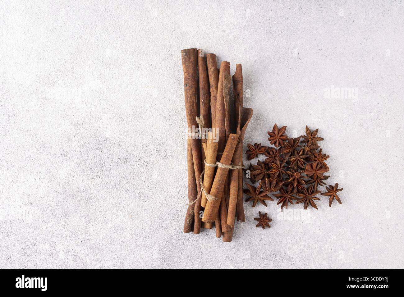 I bastoncini di cannella e l'anice stellato si trovano su gesso grigio Foto Stock