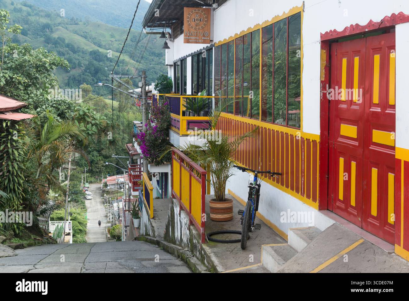 Facciata di un hotel dai colori vivaci in cima a una ripida strada ai margini della città del Salento, dipartimento di Quindío, Colombia Foto Stock